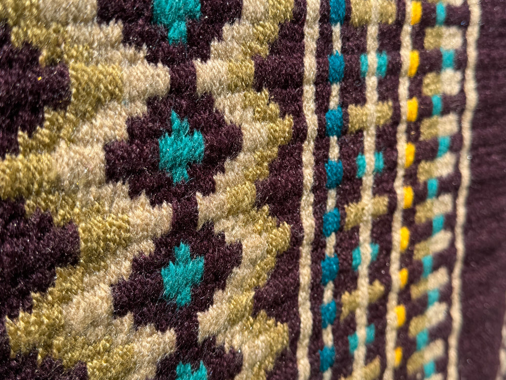 Extreme close-up detail of the tight handloom wool weave on a dark chocolate brown geometric western show pad with sandy tan, vibrant teal, and gold yellow accents.