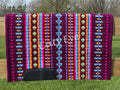 Hand-woven western show pad with a rich magenta plum-berry base featuring geometric patterns in bright orange, light turquoise blue, hot pink, purple, and yellow accents with black wear leathers.